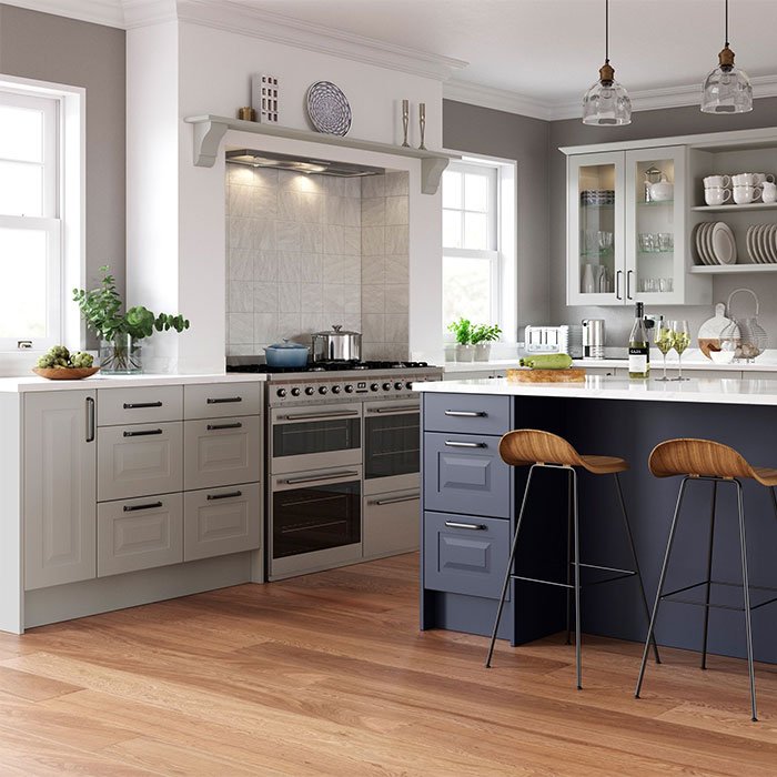 Chatham raised panel kitchen. Light Grey base units and wall units with glass inserts. Marine Blue kitchen island with drawers and seating