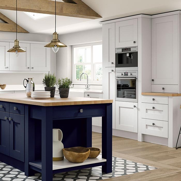 Dark blue and white shaker kitchen. White wall cabinets and base units and dark blue kitchen island with cupboards and open shelving