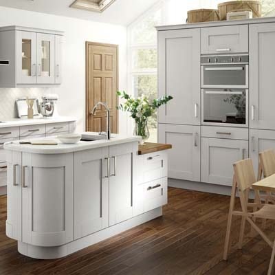 Alabany solid wood shaker in white. Glass door inserts and curved kitchen island with cupboards