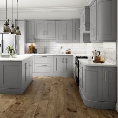 Light Grey shaker kitchen with curved cabinets, tall units with intergrated fridge freezer. Kitchen island with seating and cupboards