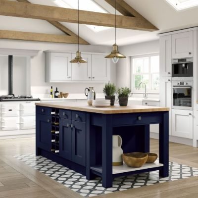 Dark blue and white shaker kitchen. White wall cabinets and base units and dark blue kitchen island with cupboards and open shelving