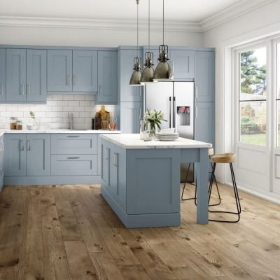 Light blue shaker kitchen and kitchen island with cupboards and seating