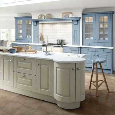 Hampton Solid Ash Timber raised panel traditional style kitchen. Tall units with glass inserts in Denim, light blue and a rounded kitchen island with cupboards and drawers in Porcelain