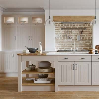 Newport grooved raised panel kitchen in cashmere beige. Tall wall units with glass inserts at the top and a kitchen island with cupboards, drawers and open shelving