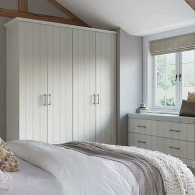 Pembrook grooved fitted wardrobes and matching fitted drawers in white wood grain.