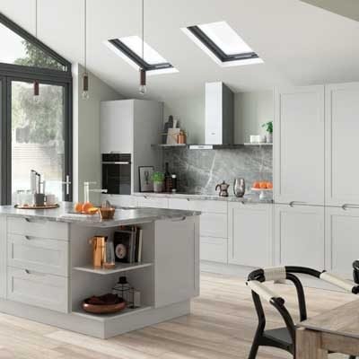 Light Grey j pull shaker kitchen with full height cabinets and built in fridge/freezer and oven. Kitchen island with drawers, cupboards and open shelving